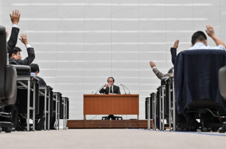 رئیس بانک مرکزی ژاپن، کازوئو اوئدا، در حالی که روزنامه نگاران دستان خود را بالا می برند تا در طی یک کنفرانس خبری پس از نشست دو روزه سیاست پولی در مقر BOJ در توکیو، در روز سه شنبه، دستان خود را برای پرسیدن سوال بالا می برند، نوشیدنی آب می خورد.